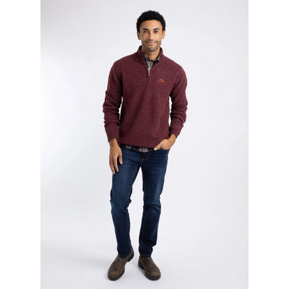 Front view of a man wearing a Weird Fish 1/4 zip Altwood knitted jumper in Garnet Red with blue jeans and brown boots.