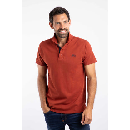 Front view of a man wearing a short sleeve Weird Fish Miles polo shirt in Burnt Henna.