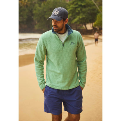 Main view of a man wearing a Weird Fish Newark 1/4 zip grid fleece in grass green with shorts