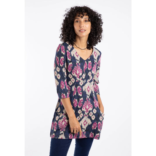 Woman wearing a Weird Fish Arielle tunic in Petrol Blue with a pink-purple abstract pattern on a white background
