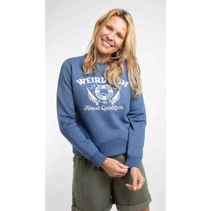 Front view of a woman wearing a Weird Fish Aurora crew neck sweatshirt in Faded Blue with a nautical logo print on the front.