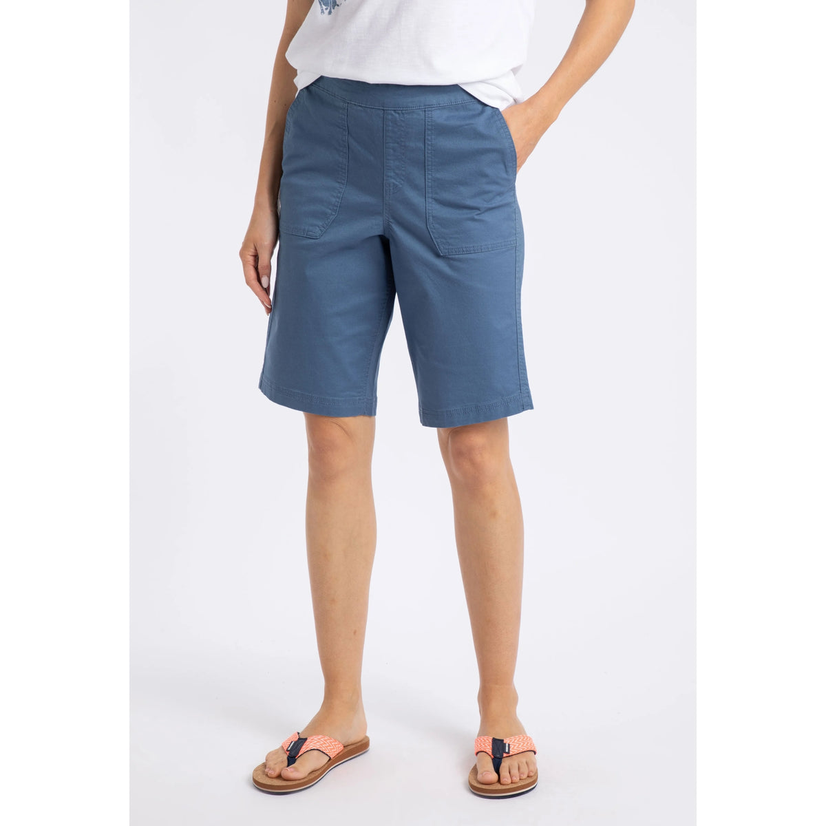 Main front view of a woman wearing a pair of Weird Fish flat front Kinnie shorts in Faded Blue with elastic waist and hip pockets.