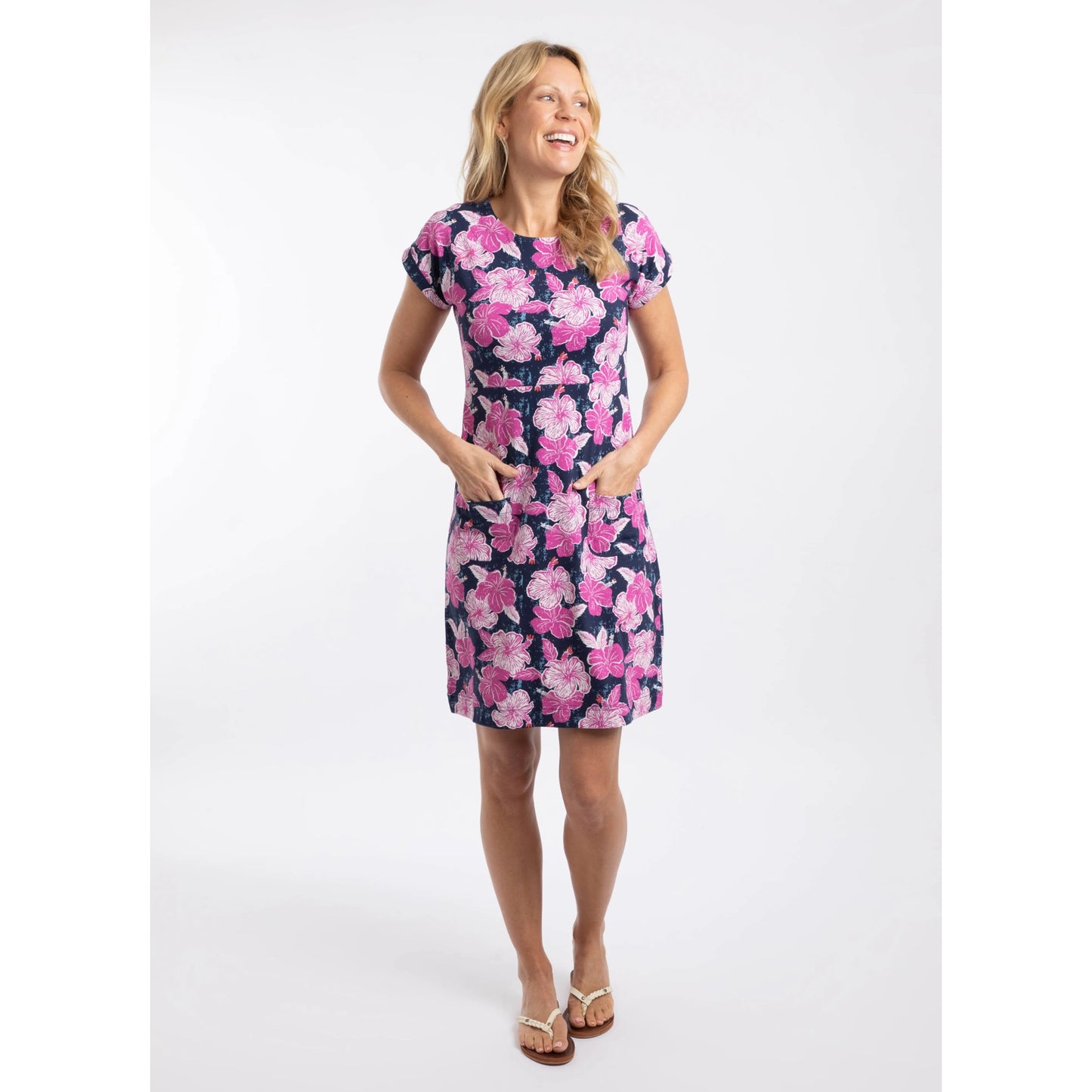 Woman wearing a Weird Fish short sleeve Tallahassee dress in Fuchsia Punch Pink with a bold floral pattern.