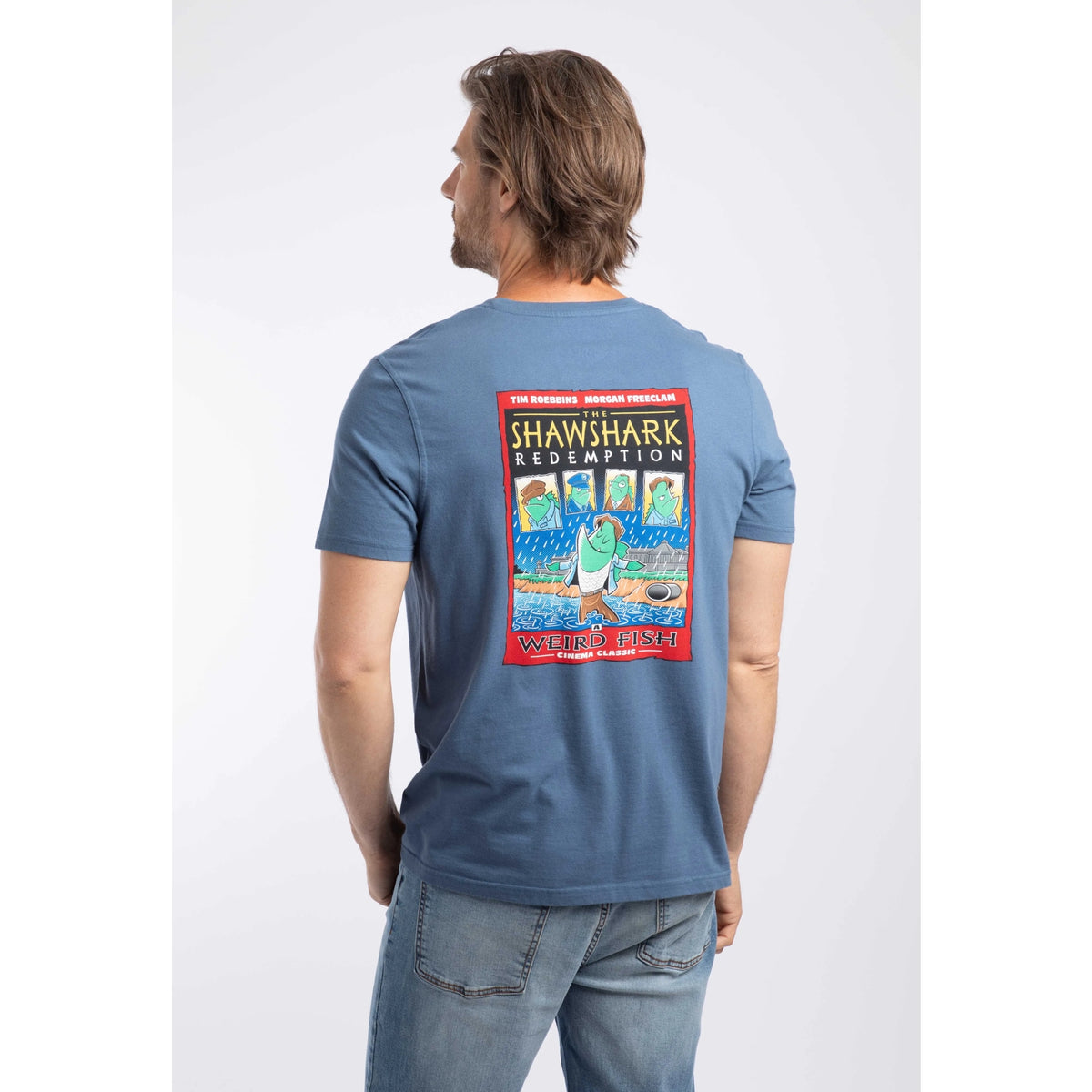 Back view of a man wearing a short sleeve t-shirt in Ensign Blue, featuring a large Shawshark Redemption parody print of The Shawshank Redemption film poster.