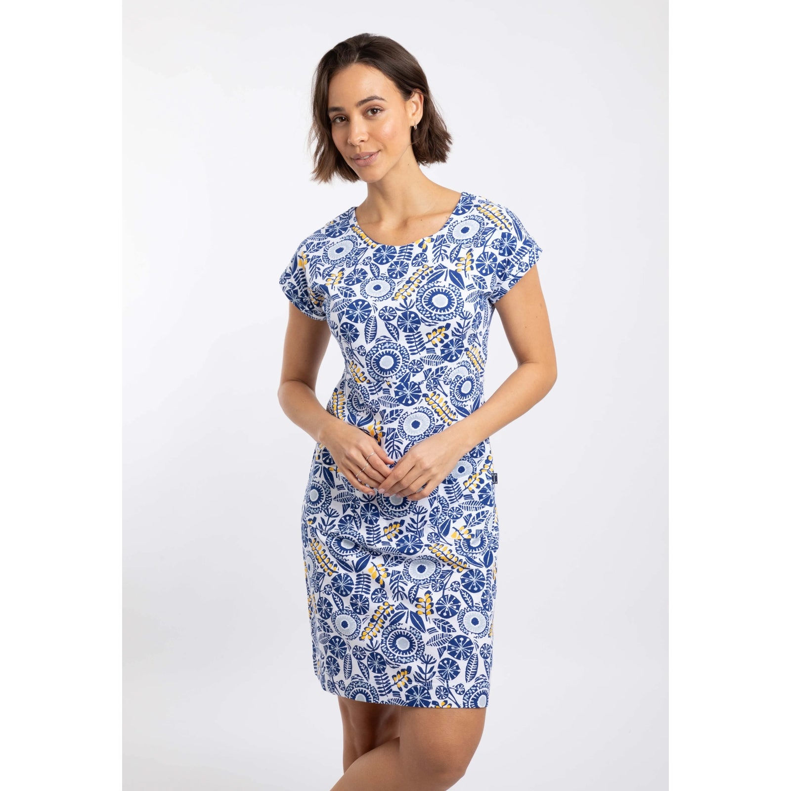 Front view of a woman wearing a Weird Fish short sleeve Tallahassee dress in Sapphire Blue featuring an abstract floral print and front pockets.