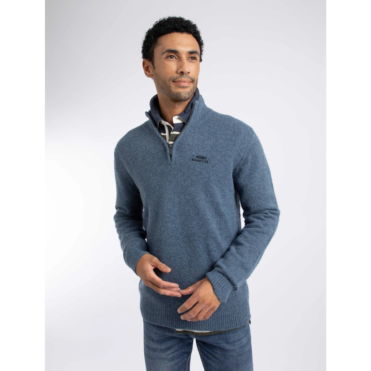 Front view of a man wearing a Weird Fish 1/4 zip Altwood knitted jumper in Ash Blue over a polo shirt with blue jeans