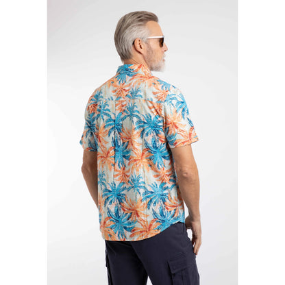 Back view of a man wearing a Weird Fish short sleeve Faraway shirt in Paprika orange and blue with a tropical palm tree pattern and navy shorts