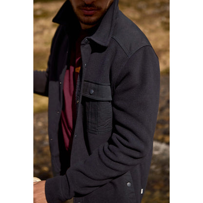 Man wearing a Weird Fish dark navy Boyd fleece jacket with a blurred natural background