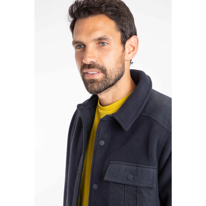 Man wearing a dark navy Weird Fish Boyd fleece jacket over a yellow shirt on a white background