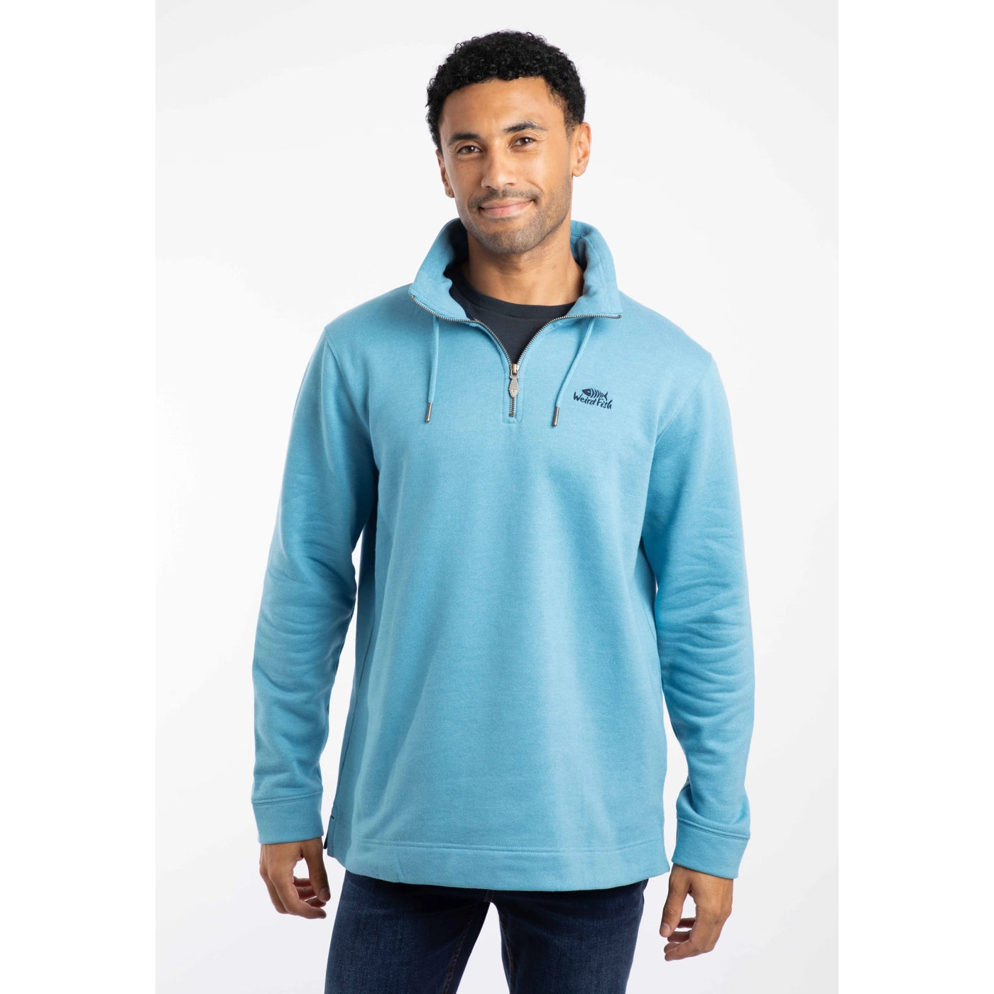Man wearing a Weird Fish Smoked Blue Brampton pullover sweatshirt with a logo on a white background