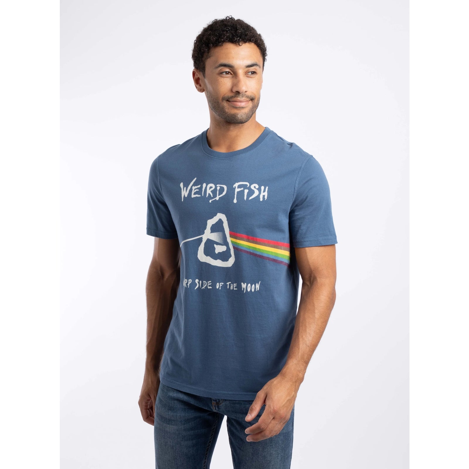 Front view of a man wearing a Weird Fish 'Carp Side of the Moon' printed short sleeve t-shirt in Ensign Blue, featuring a Pink Floyd themed graphic print, with the text 'WEIRD FISH' and 'CARP SIDE OF THE MOON'.