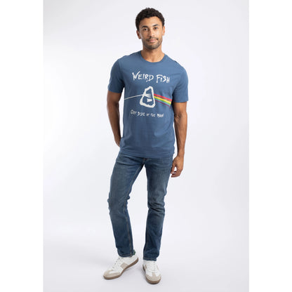 Man wearing a Weird Fish 'Carp Side of the Moon' printed short sleeve t-shirt in Ensign Blue, with blue jeans and white trainers.