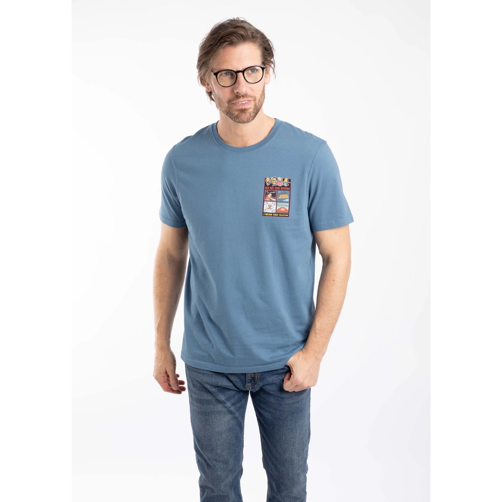 Front view of a man wearing a Weird Fish mens short sleeve Chili Kippers t-shirt in Washed Blue with a small Red Hot Chili Kippers album themed print on the front