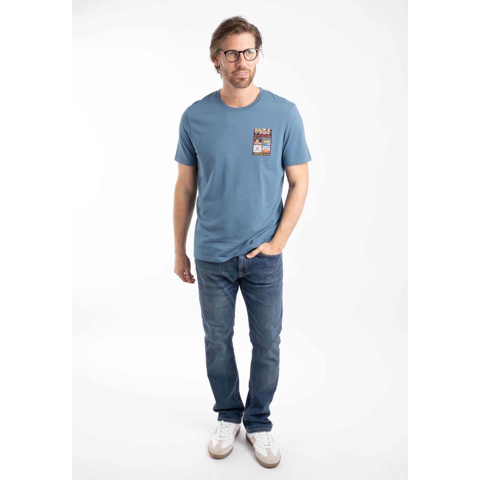 Man wearing a Weird Fish mens short sleeve Chili Kippers t-shirt in Washed Blue with jeans and white trainers.