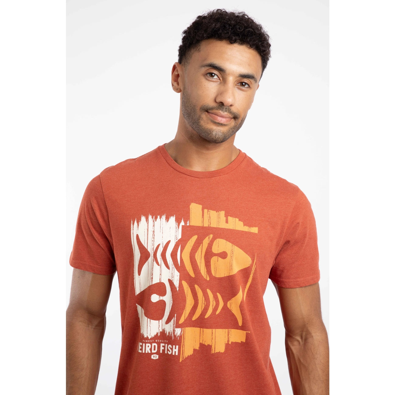 Closeup of a man wearing a Weird Fish short sleeve Double Fish Rust Leaves colour t-shirt with a distressed style fishbones logo print on a white background