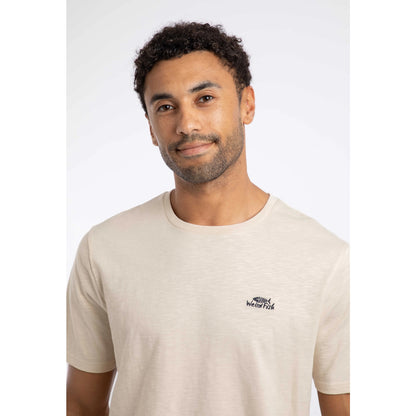 Close-up view of a man wearing a Weird Fish crew neck short sleeve Fished t-shirt in Egg Shell with small logo on one side of the chest.