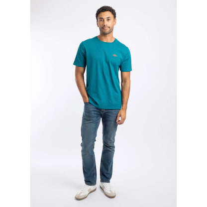A man wearing a Weird Fish crew neck short sleeve Fished t-shirt in Blue Teal with small logo on one side of the chest with blue jeans and white trainers.