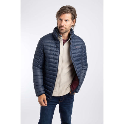 A man wearing a Weird Fish Crantock padded jacket in navy unzipped.