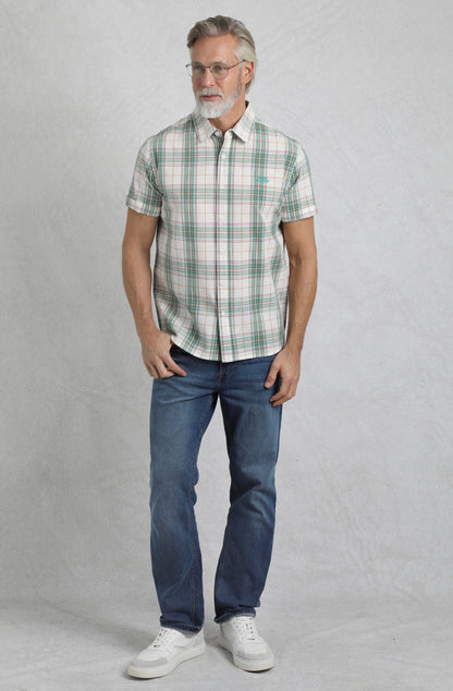 Weird Fish mens Judd check shirt Viridis Green worn by male model with glasses paired with blue jeans and white sneakers
