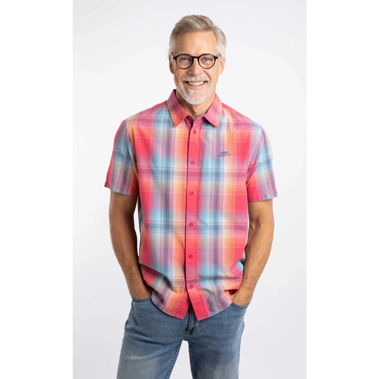 A man wearing a Weird Fish short sleeve Judd shirt in a bright Flamingo Pink, blue and orange check pattern with blue jeans.