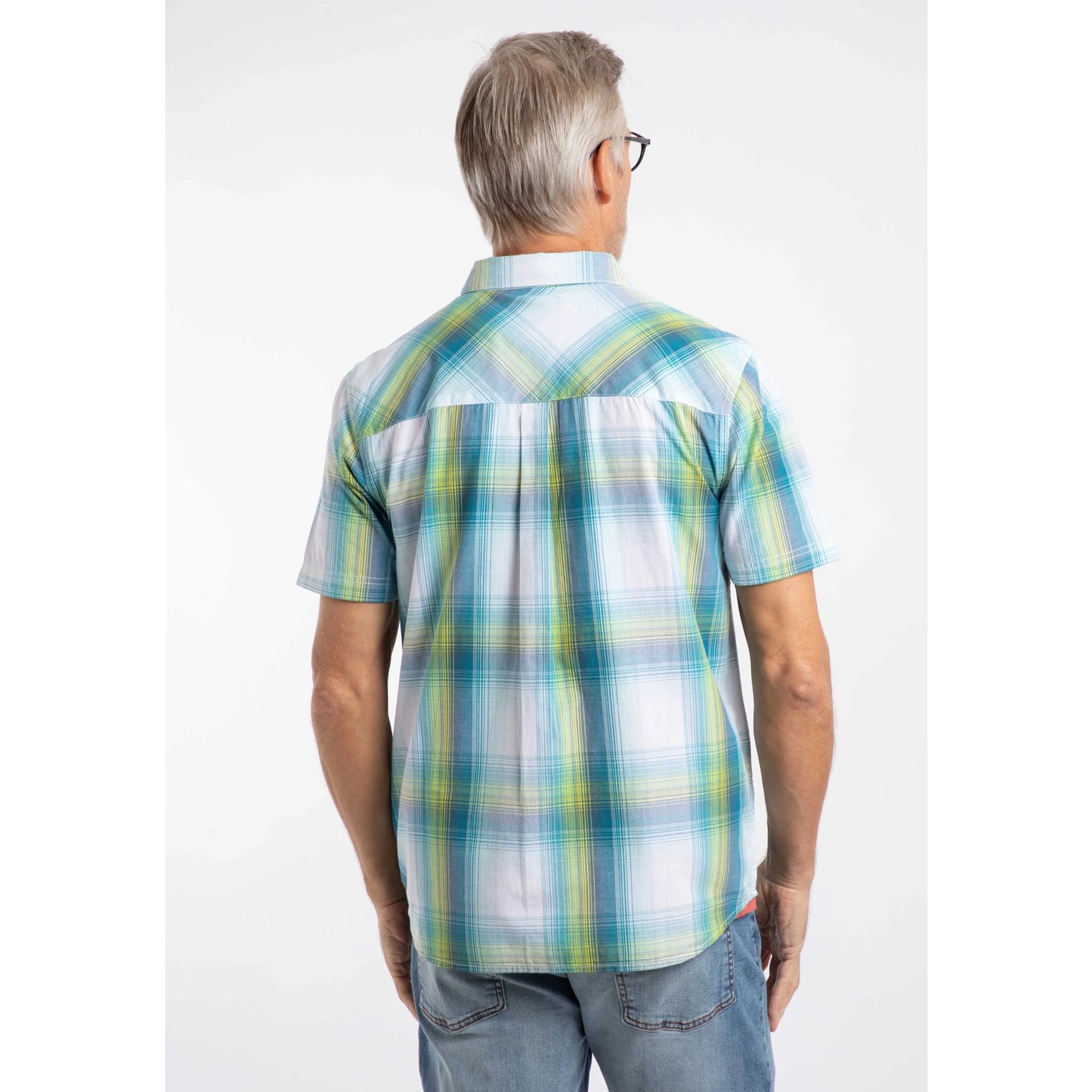 Back view of a man wearing a Weird Fish short sleeve Judd shirt in an off white, blue and lime green check pattern with blue jeans.