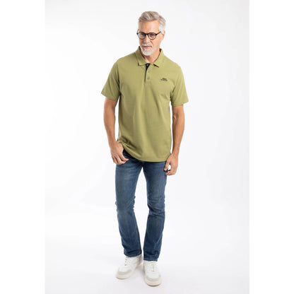 A man wearing a Weird Fish short sleeve Miles polo shirt in Washed Oak Green with blue jeans.