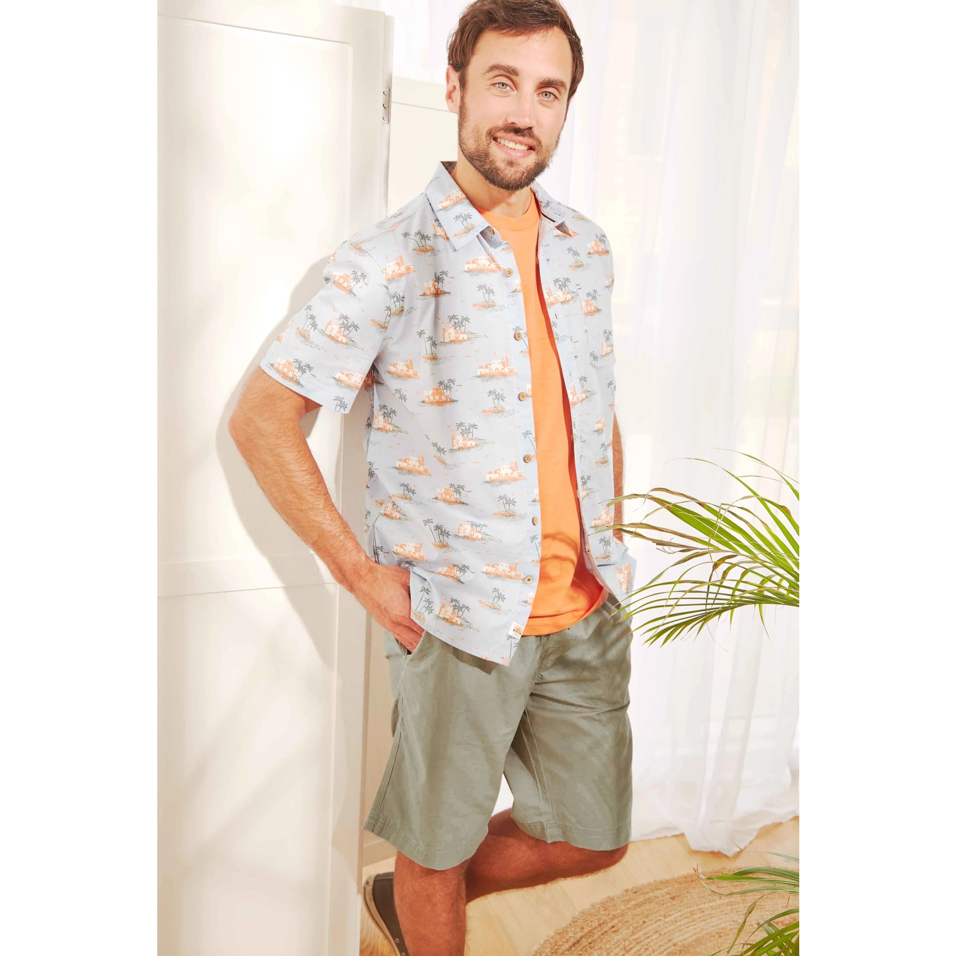 Weird Fish mens Murrisk shorts shadow in green worn by man with patterned shirt and orange t-shirt