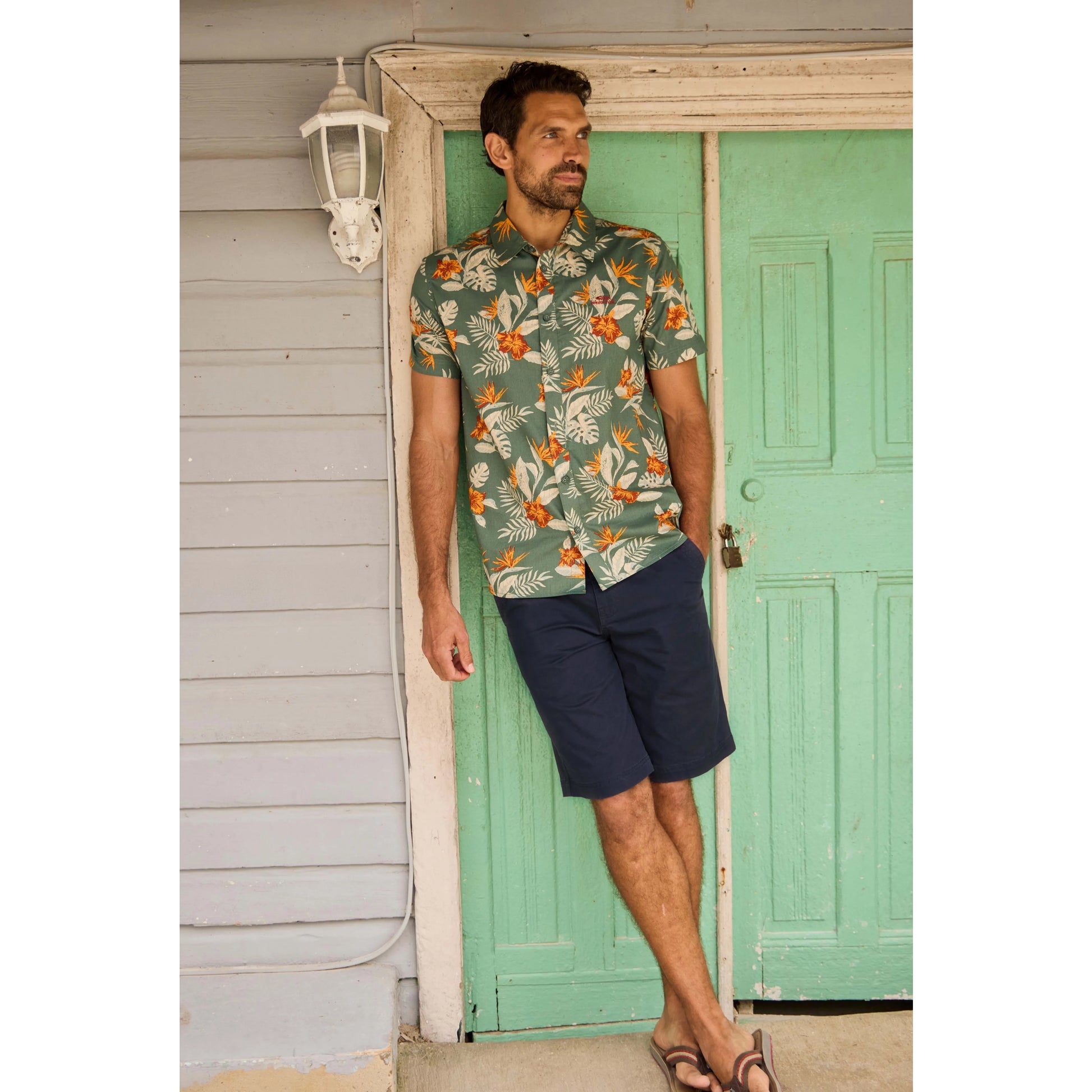 Man wearing Weird Fish mens navy Rayburn chino shorts with a tropical short sleeve shirt and sandals