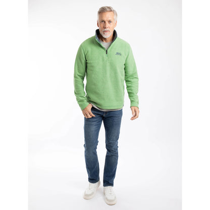 Man wearing a Weird Fish Newark 1/4 zip grid fleece in grass green, with blue jeans and trainers