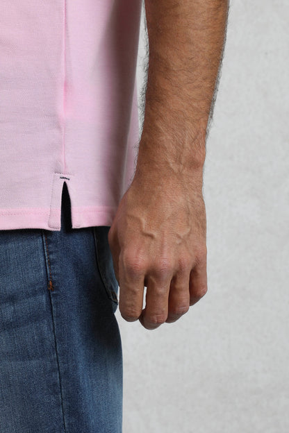 Close-up of Weird Fish mens pink polo shirt hem and side slit worn with blue jeans