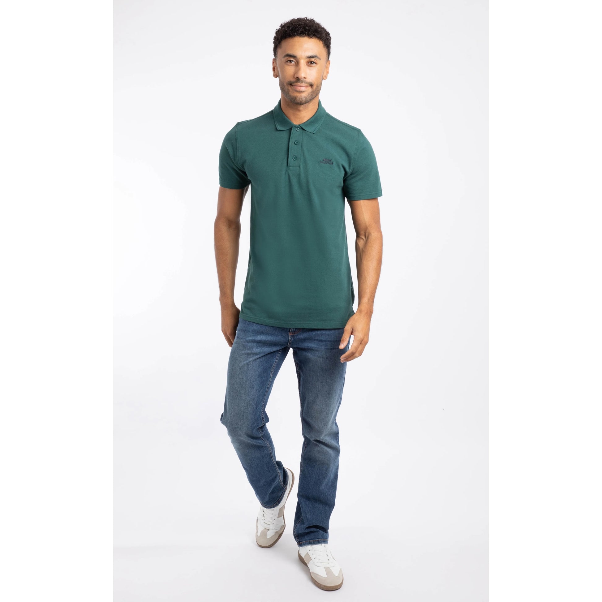 Weird Fish mens polo shirt Forest Green worn by man paired with blue jeans and white sneakers
