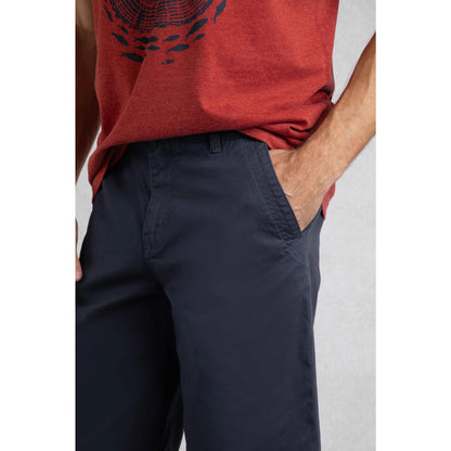 Close-up of Weird Fish mens Rayburn navy chino shorts worn with a red graphic t-shirt showing pocket detail