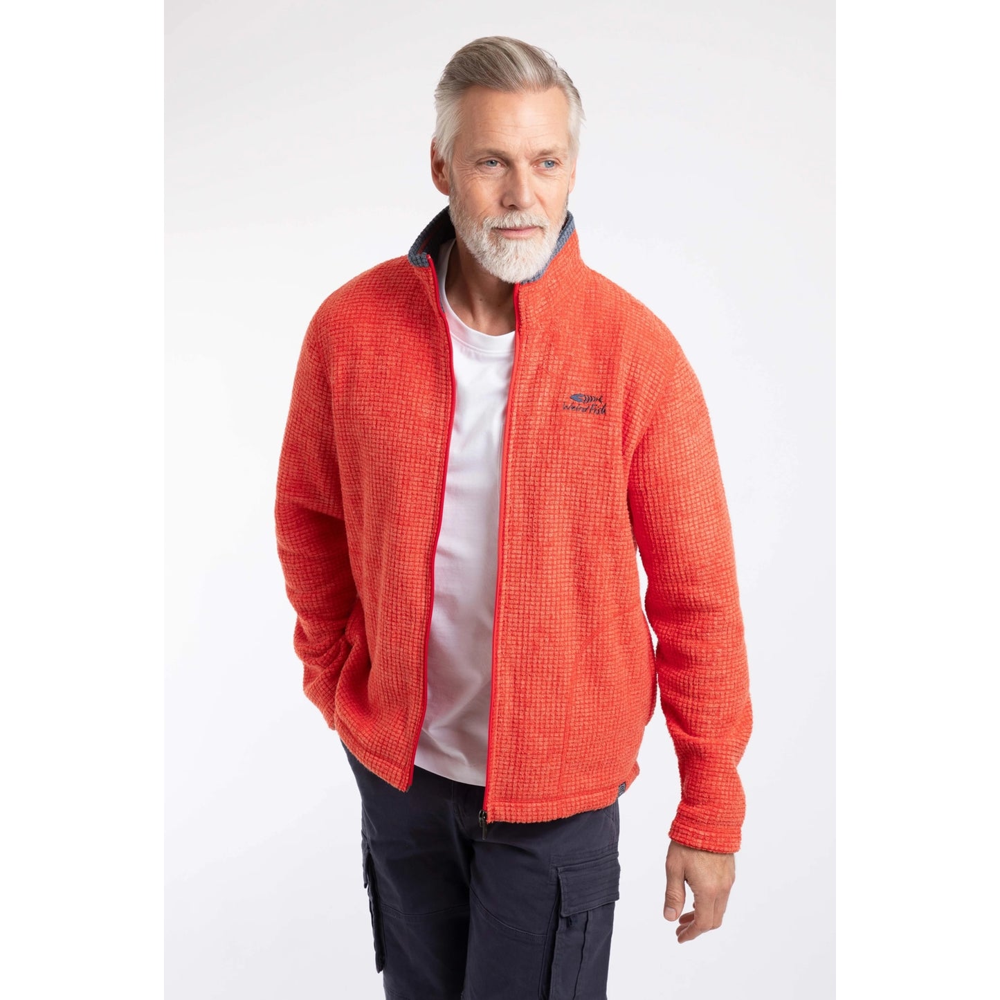 Front view of a man wearing a Weird Fish full zip Shires grid textured fleece in bright Orange Spice unzipped with a white t-shirt, contrasting navy neckline and small chest logo with navy shorts