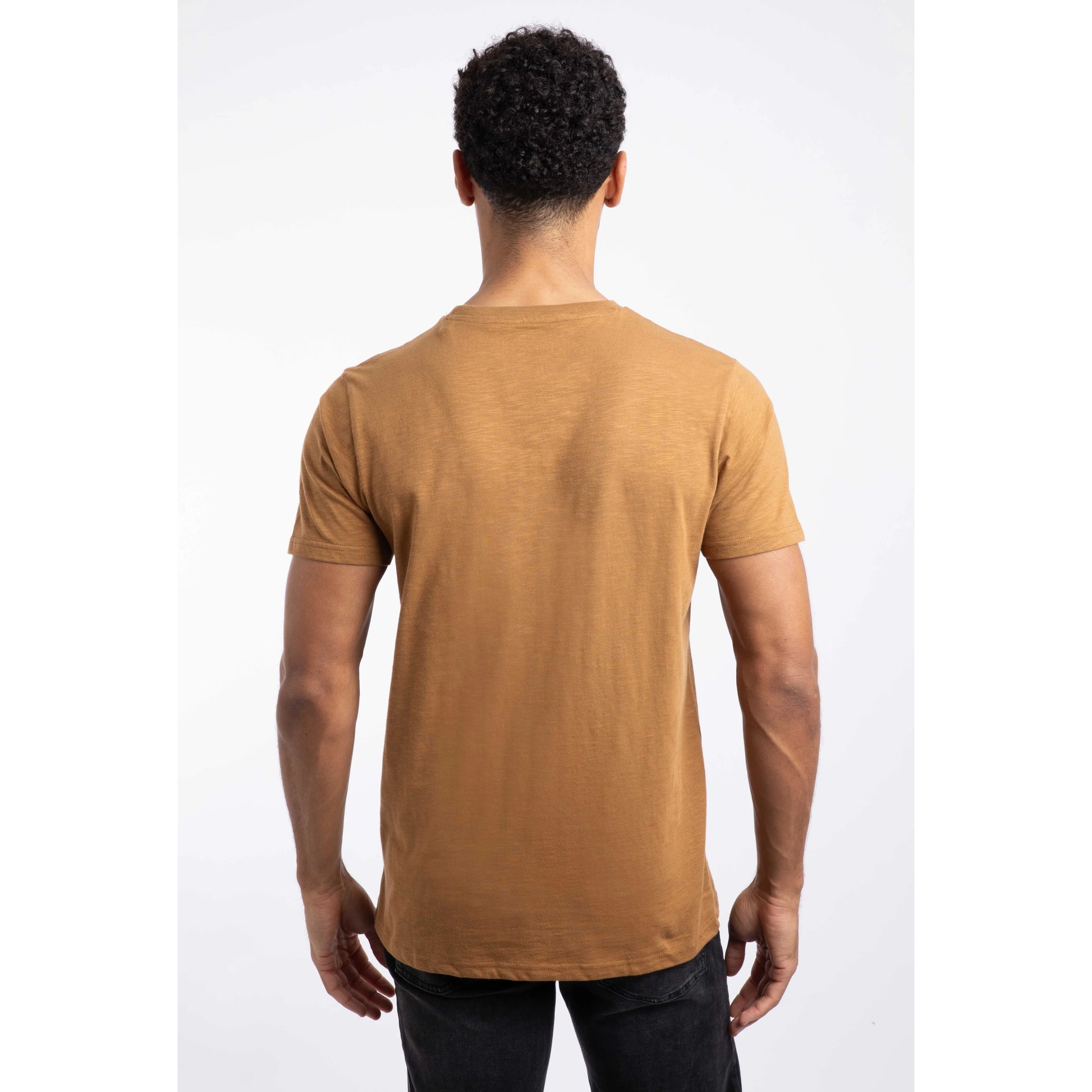 Back view of a man wearing Weird Fish mens t-shirt Fox brown with short sleeves and black pants