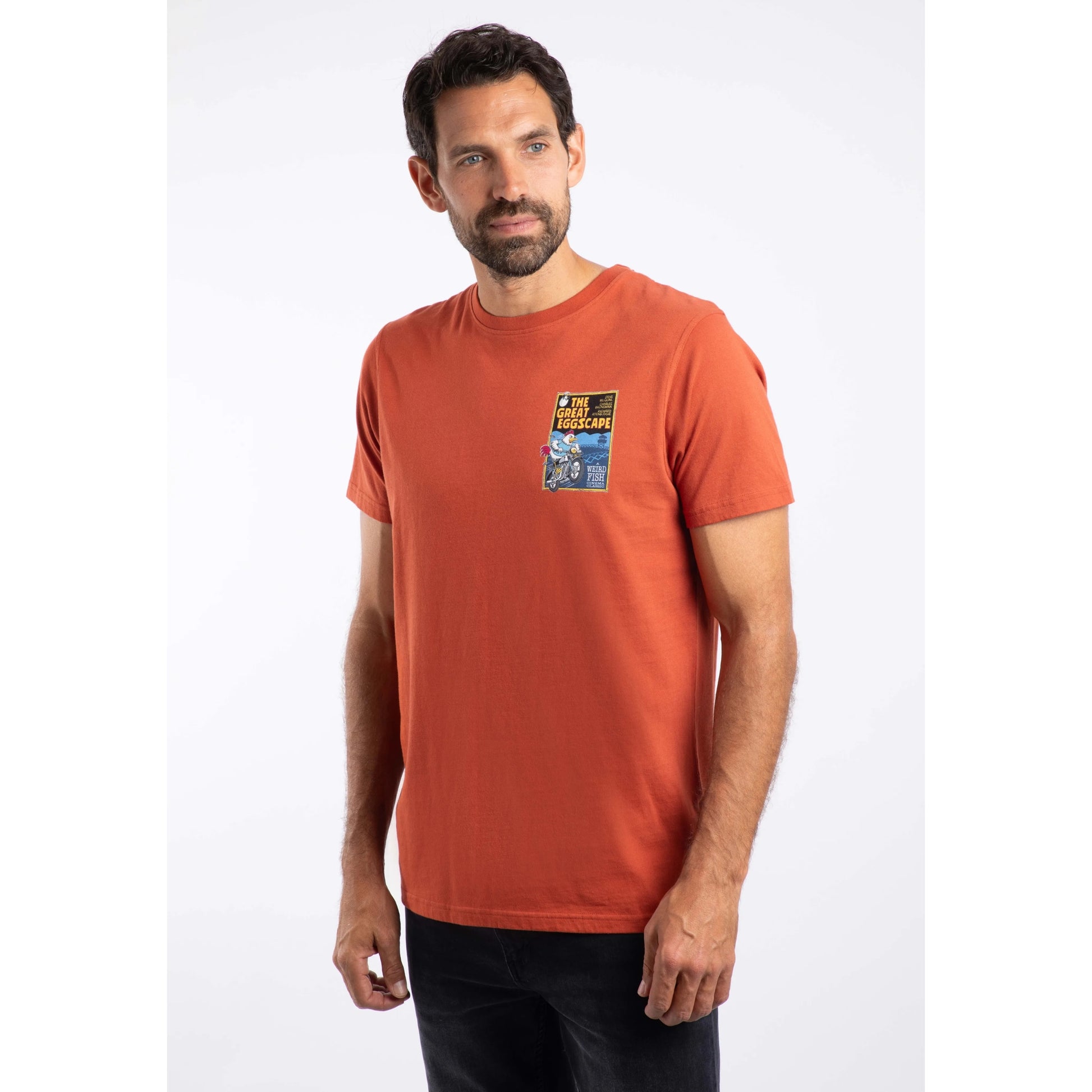 Man wearing an orange t-shirt with a graphic design on a white background