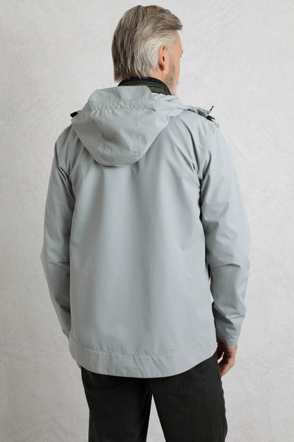 Back view of a man wearing a Weird Fish mens waterproof jacket grey with hood in a light grey color