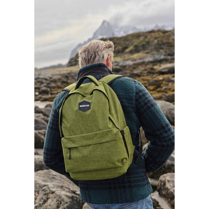 Person wearing a green Weird Fish Nevis backpack in a mountainous landscape