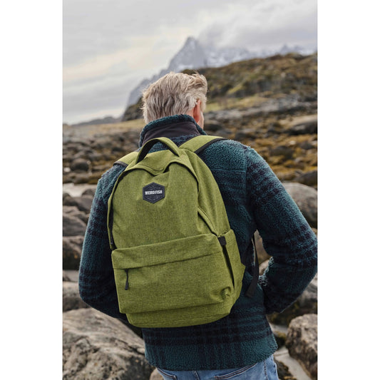 Person wearing a green Weird Fish Nevis backpack in a mountainous landscape