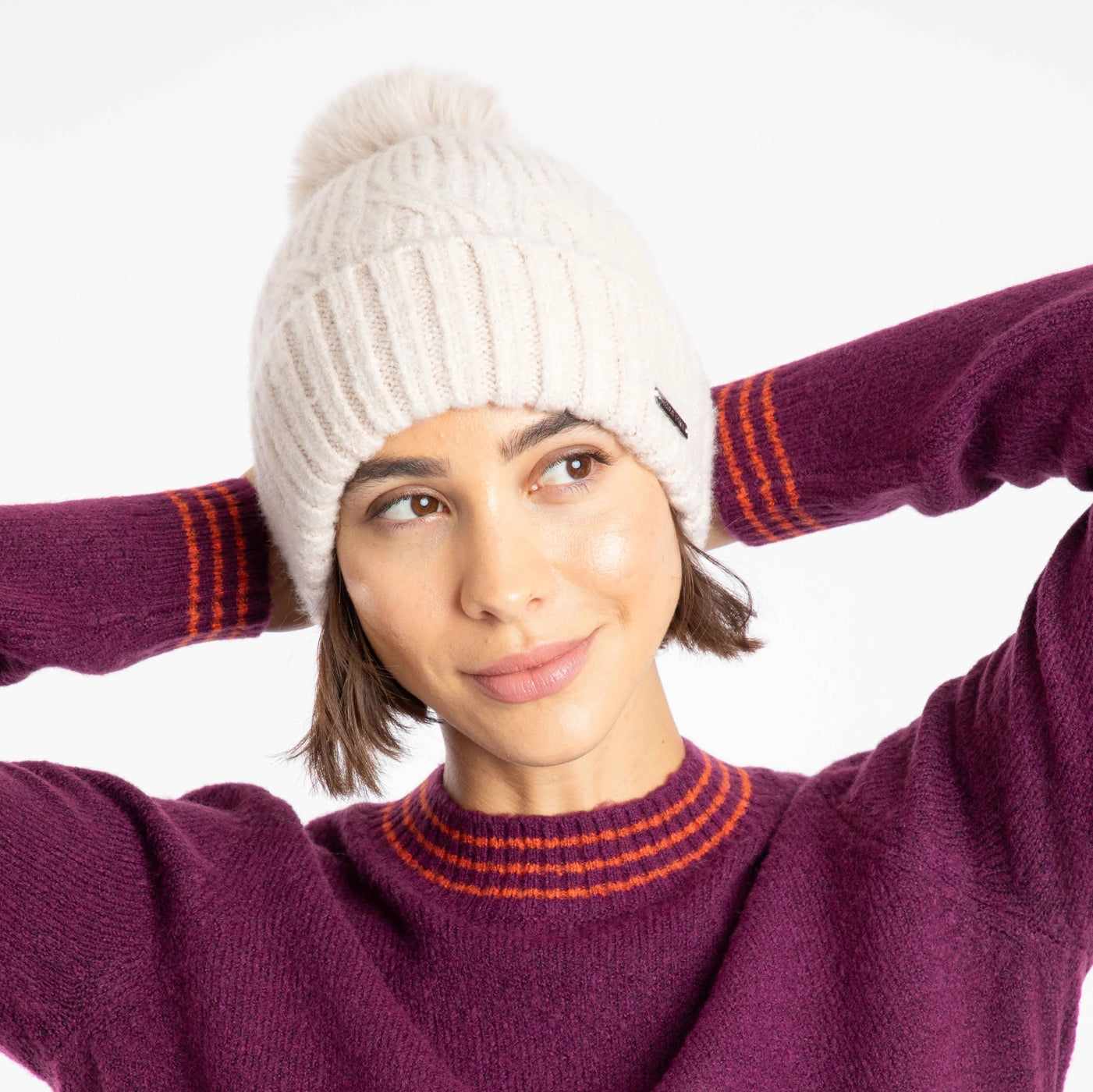 Woman wearing a Weird Fish white Blagdon sparkle knit beanie and purple sweater with orange accents on a white background