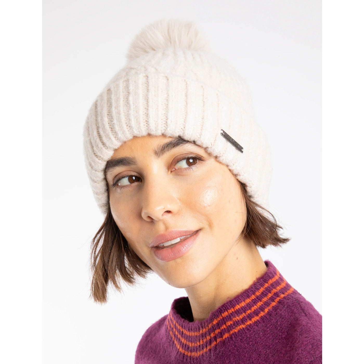 Woman wearing a chalk white Weird Fish knitted Blagdon beanie and a purple sweater with orange stripes on a white background