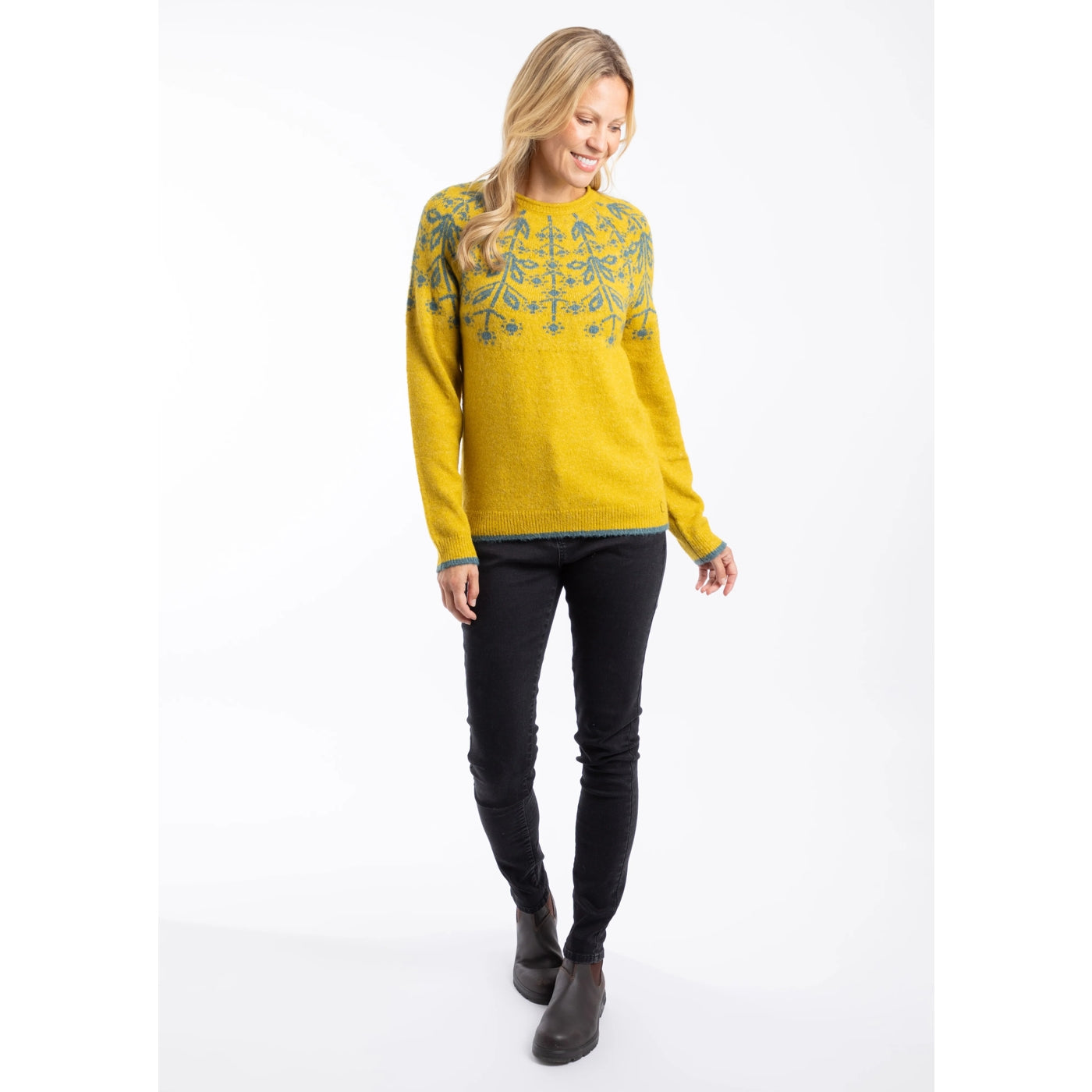 Woman wearing a yellow Weird Fish Miska knitted jumper with a Fair Isle pattern with beige trousers on a white background