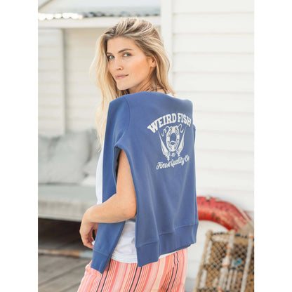 A woman with a Weird Fish Aurora crew neck sweatshirt in Faded Blue draped across the back of her shoulders.