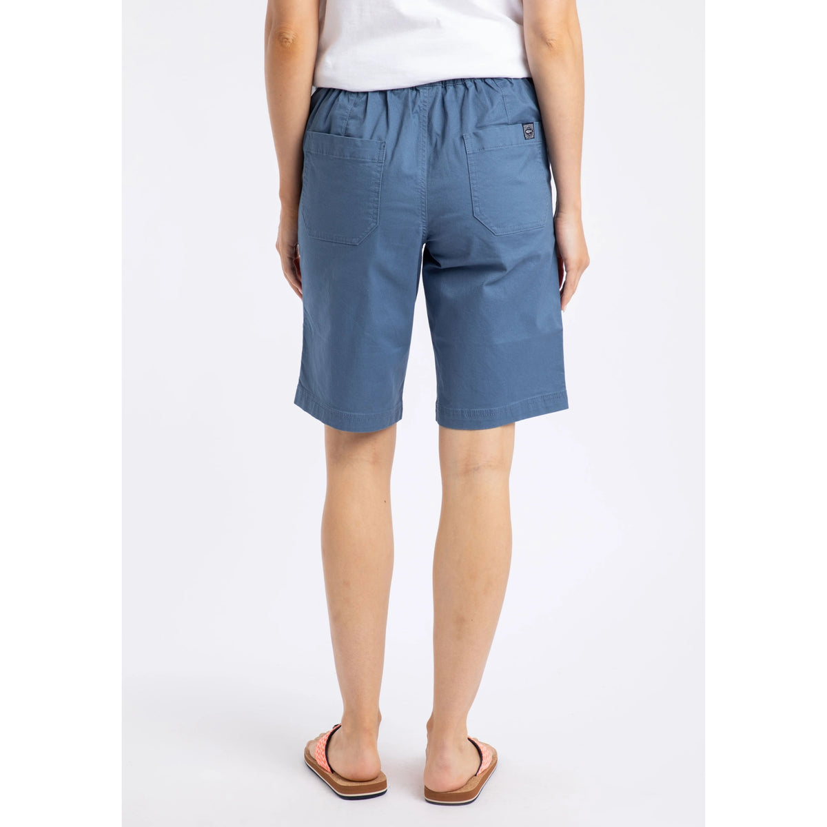 Back view of a woman wearing a pair of Weird Fish flat front Kinnie shorts in Faded Blue with elastic waist and hip pockets.