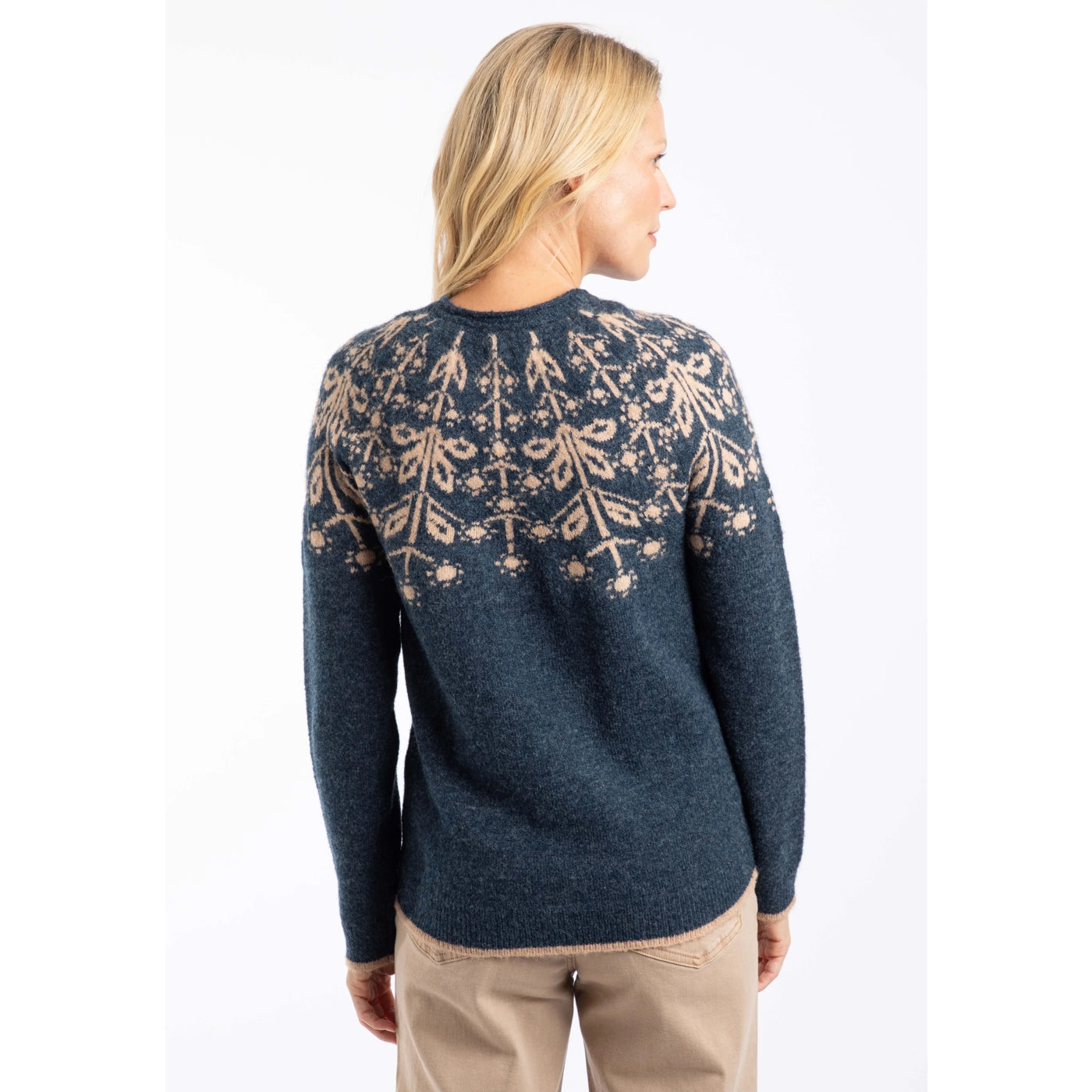 Back view of a woman wearing a Weird Fish navy Miska jumper with a beige Fair Isle pattern and beige trousers.