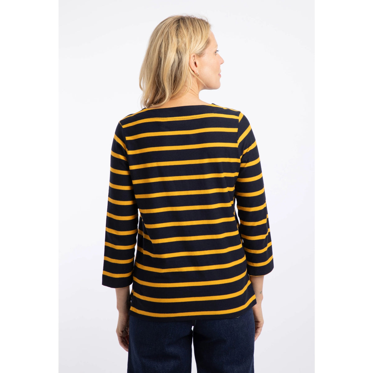 Back view of a woman wearing a Weird Fish Saffira 3/4 length sleeve top in Midnight Navy with Gold Yellow stripes.