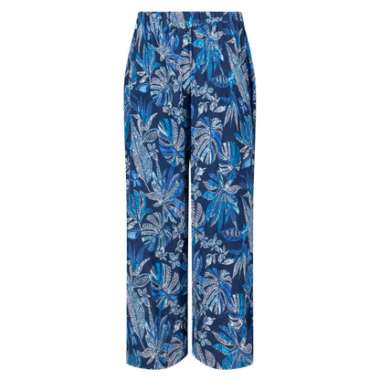 Back view of a pair of women's Weird Fish Sarita wide leg crinkle viscose cropped trousers in indigo blue with a tropical leaf pattern.