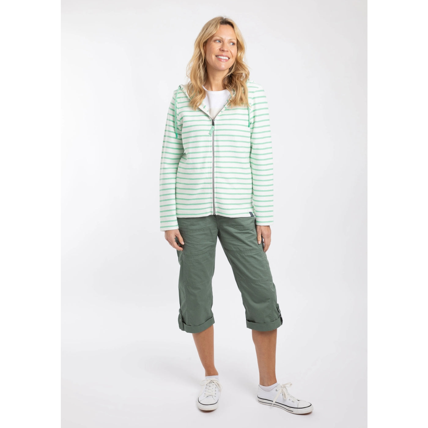 Woman wearing a Weird Fish Catalina full zip loopback hoodie in  an Apple Mint green and white stripe pattern with green crop trousers