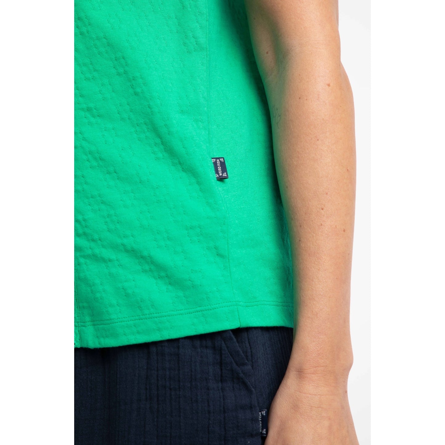 Close-up view of the logo label of a womens Weird Fish Chelle square neck vest in Gumdrop Green