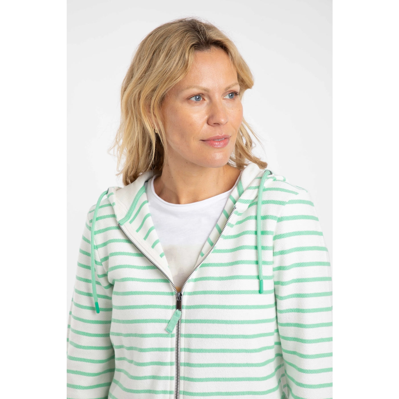 Close up-view of a woman wearing a Weird Fish Catalina full zip loopback hoodie in  an Apple Mint green and white stripe pattern