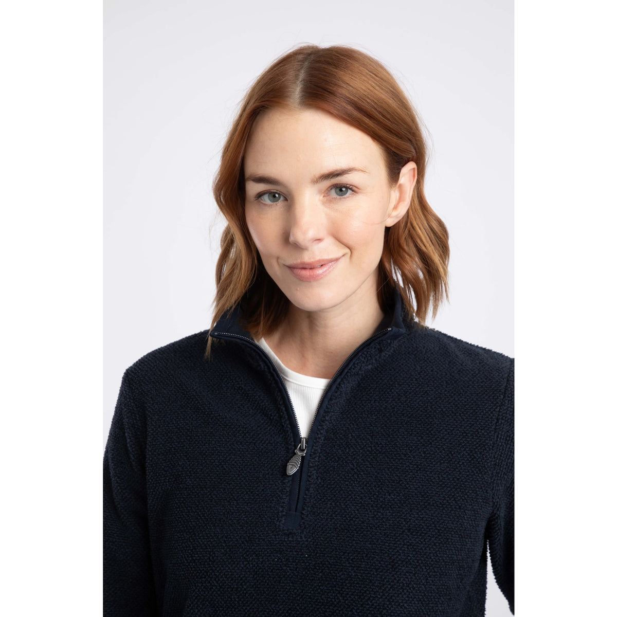 Close-up view of a woman wearing a Weird Fish 1/4 zip Sarah fleece in Midnight Navy